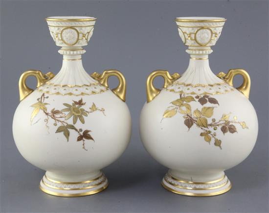 A pair of Royal Worcester ivory ground twin handled vases, date code for 1887, height 23cm